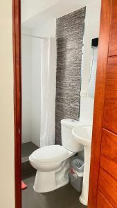 a bathroom with a white toilet and a sink at Aparthotel Cusco in San Antonio