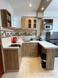 a kitchen with wooden cabinets and a red pot on the counter at Aparthotel Cusco in San Antonio