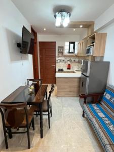 a kitchen and dining room with a table and chairs at Aparthotel Cusco in San Antonio