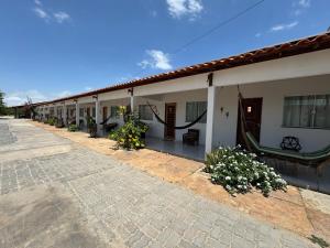 a row of houses with flowers in the courtyard at Pousada Cajueiro Do Sol in Barreirinhas