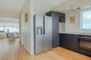 a kitchen with a stainless steel refrigerator in a room at Luxury Townhouse with Panoramic Sea View in Tórshavn +18 photos