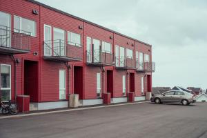 a car parked in front of a red building at Luxury Townhouse with Panoramic Sea View in Tórshavn