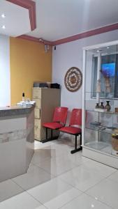 a room with two red chairs and a counter at Hotel Capim Dourado in Palmas