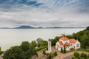 an aerial view of a church on the shore of a lake at Apartments in Balatonfenyves - Balaton 18466 in Balatonfenyves
