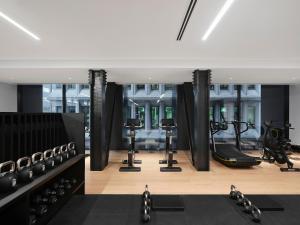 a gym with treadmills and exercise equipment in a building at Little National Hotel Adelaide in Adelaide