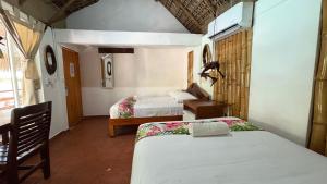 a room with two beds and a chair in it at Hotel Frida Paradise in Brisas de Zicatela +26 photos