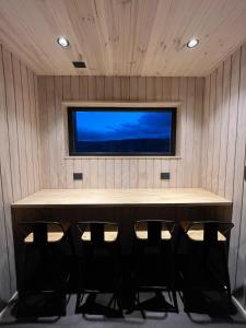 a room with a table and four chairs in front of a tv at Refuge with Panoramic Views, Cerro Castillo in Villa Cerro Castillo