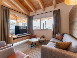 a living room with a couch and a tv at Grebenzen Lodges 49B in Sankt Lambrecht