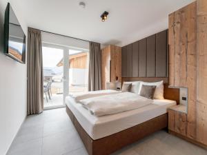 a bedroom with a large bed and a balcony at Grebenzen Lodges 49B in Sankt Lambrecht