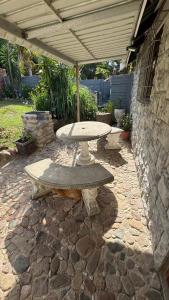 a stone patio with a table and an umbrella at Ahava Accommodation in Scottburgh