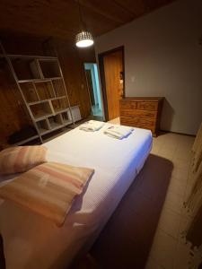 a bedroom with a large white bed and a dresser at Hostería Altas Cumbres in El Chalten