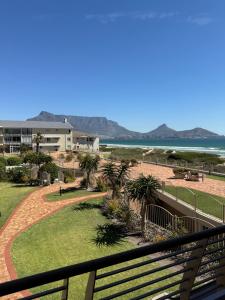 a view of the beach from the balcony of a resort at Cozy Apartment with Table Mountain and beach views in Cape Town