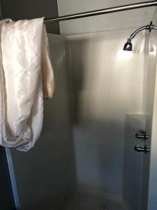 a bathroom with a shower with a bag on the wall at The Moonie Crossroads Hotel in Moonie