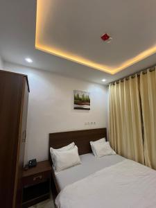 a bedroom with a bed with white sheets at Grand Lynks Homes and Apartments in Gwarinpa