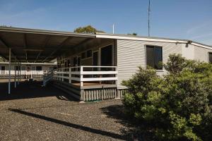 a small white building with a porch and a porch at The Moonie Crossroads Hotel in Moonie