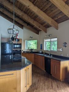 a large kitchen with wooden cabinets and black counter tops at Argo's Landing in Bamfield
