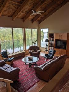 a living room with couches and a table and chairs at Argo's Landing in Bamfield