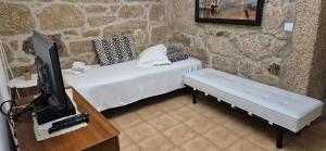 a bedroom with a bed and a tv and a table at Casa da Massada in Belmonte