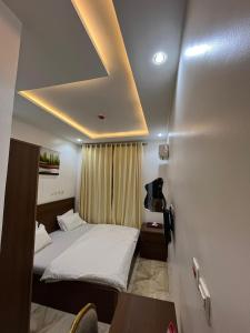 a hotel room with a bed and a ceiling with a table at Grand Lynks Homes and Apartments in Gwarinpa
