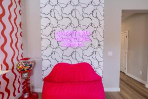 a red chair in a room with a wall at Near Airport, 3BR, Stock Tank Pool, Mini-Golf, Game Rm in Commerce City +38 photos