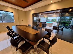 a dining room with a wooden table and chairs at Hotel Brasil in Caazapa New