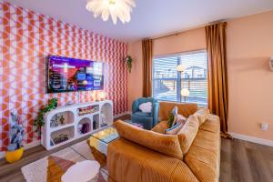 a living room with a couch and a tv at Near Airport, 3BR, Stock Tank Pool, Mini-Golf, Game Rm in Commerce City