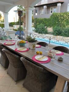 a long wooden table with chairs and food on it at Villa Erato in Rafina