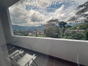 a room with chairs and a large window with a view at Imperial Emerald House in Muzo