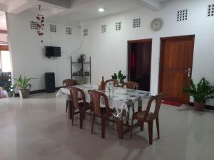 a dining room with a white table and chairs at Pasikuda Shalom Echo Villa in Palayadithona