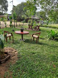 a picnic table and benches in a park at Pasikuda Shalom Echo Villa in Palayadithona