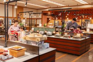a group of people preparing food in a restaurant at Ooedo Onsen Monogatari Yamanaka Saichoraku in Kaga