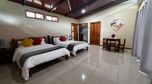 a bedroom with two beds and a table in it at Chirripó Oasis in Canaán