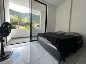 a bedroom with a bed and a large window at Imperial Emerald House in Muzo +6 photos