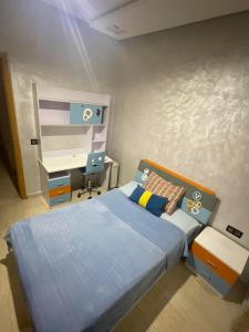 a small bedroom with a bed and a desk at إقامة حسن in Fez