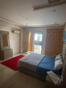 a bedroom with a bed with a red rug and a window at إقامة حسن in Fez