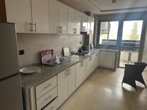 a kitchen with white cabinets and a counter top at إقامة حسن in Fez