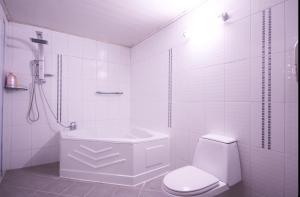 a white bathroom with a toilet and a bath tub at Dongdaegu Leaders Hotel in Daegu