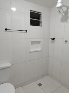 a white bathroom with a shower with a glass door at Hospedaria Temporarte in Piranhas +84 photos