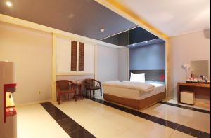 a bedroom with a bed and a table and chairs at Dongdaegu Leaders Hotel in Daegu +6 photos