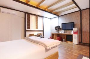 a bedroom with a bed and a flat screen tv at Dongdaegu Leaders Hotel in Daegu