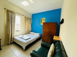 a small bedroom with a bed and a couch at Hostal Colombia plaza in San Gil