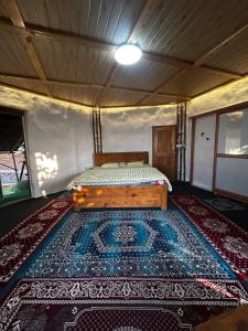 ein Bett in einem Zimmer mit einem Teppich auf dem Boden in der Unterkunft NESTORY forest retreat in Kolvan