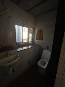 ein kleines Badezimmer mit Toilette und Waschbecken in der Unterkunft NESTORY forest retreat in Kolvan