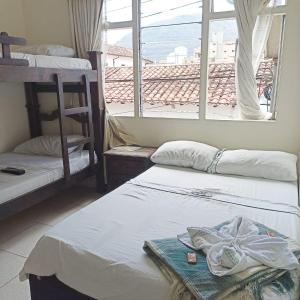 a room with two beds and a window at Hostal Colombia plaza in San Gil +8 photos