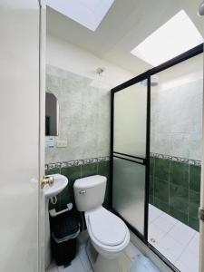 a bathroom with a toilet and a shower and a sink at Hostal Colombia plaza in San Gil