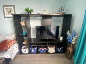 a black entertainment center with a flat screen tv at Beachfront Condo with Amazing Ocean Views 4th Fl in Old Orchard Beach