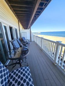 a porch with chairs and a table and the beach at Beachfront Condo with Amazing Ocean Views 4th Fl in Old Orchard Beach