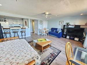 a living room with a blue couch and a kitchen at Beachfront Condo with Amazing Ocean Views 4th Fl in Old Orchard Beach