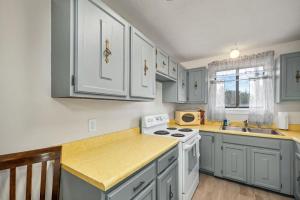 a kitchen with white cabinets and a white stove top oven at Condo Ideal location Ski, Shop, Hike in Conway