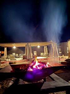 a fire pit at night with a building in the background at Royal Sands Camp - Erg Chigaga Luxury Camp in Mhamid